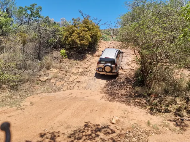 A 4x4 vehicle climbing the Gert se Klip obstacle in the bushveld.
